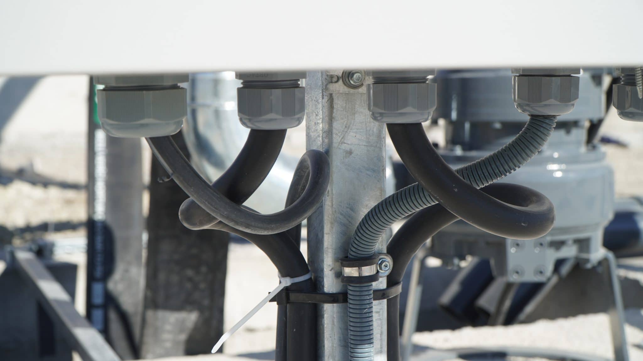 Close-up of agricultural machinery with hoses and electrical connections.