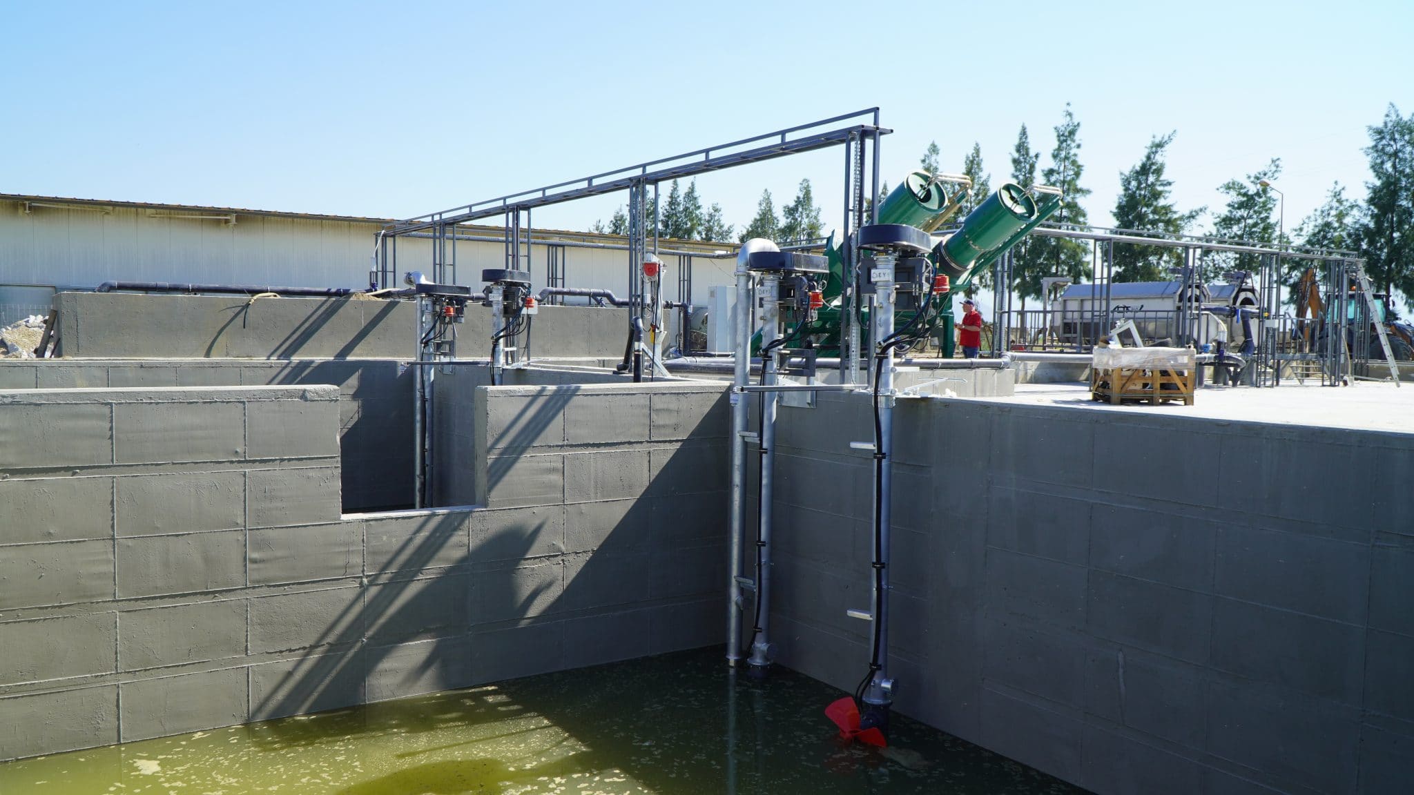 Water treatment plant with pipes and machinery in an outdoor setting.