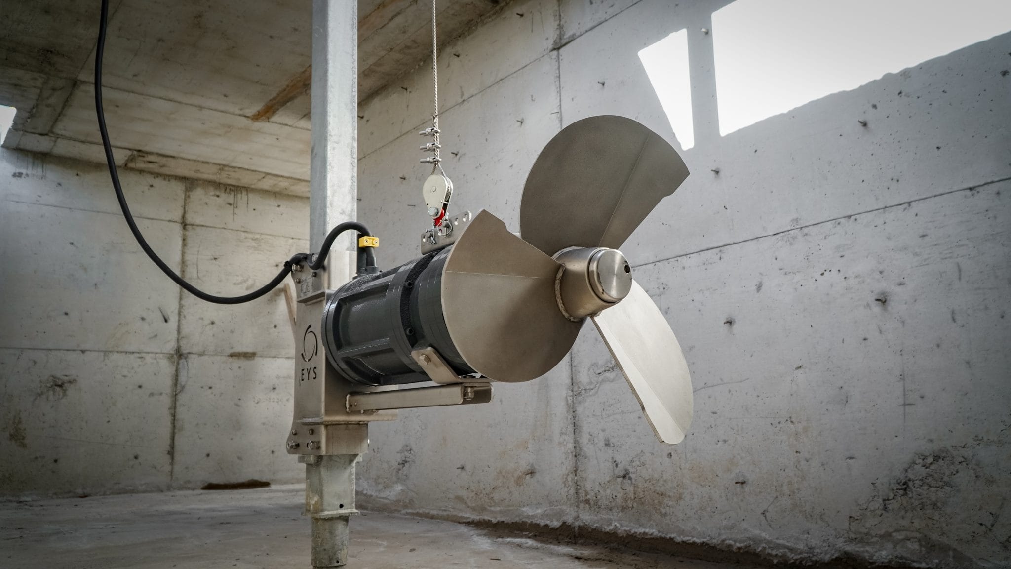 Agricultural machinery with a large fan in a concrete setting.
