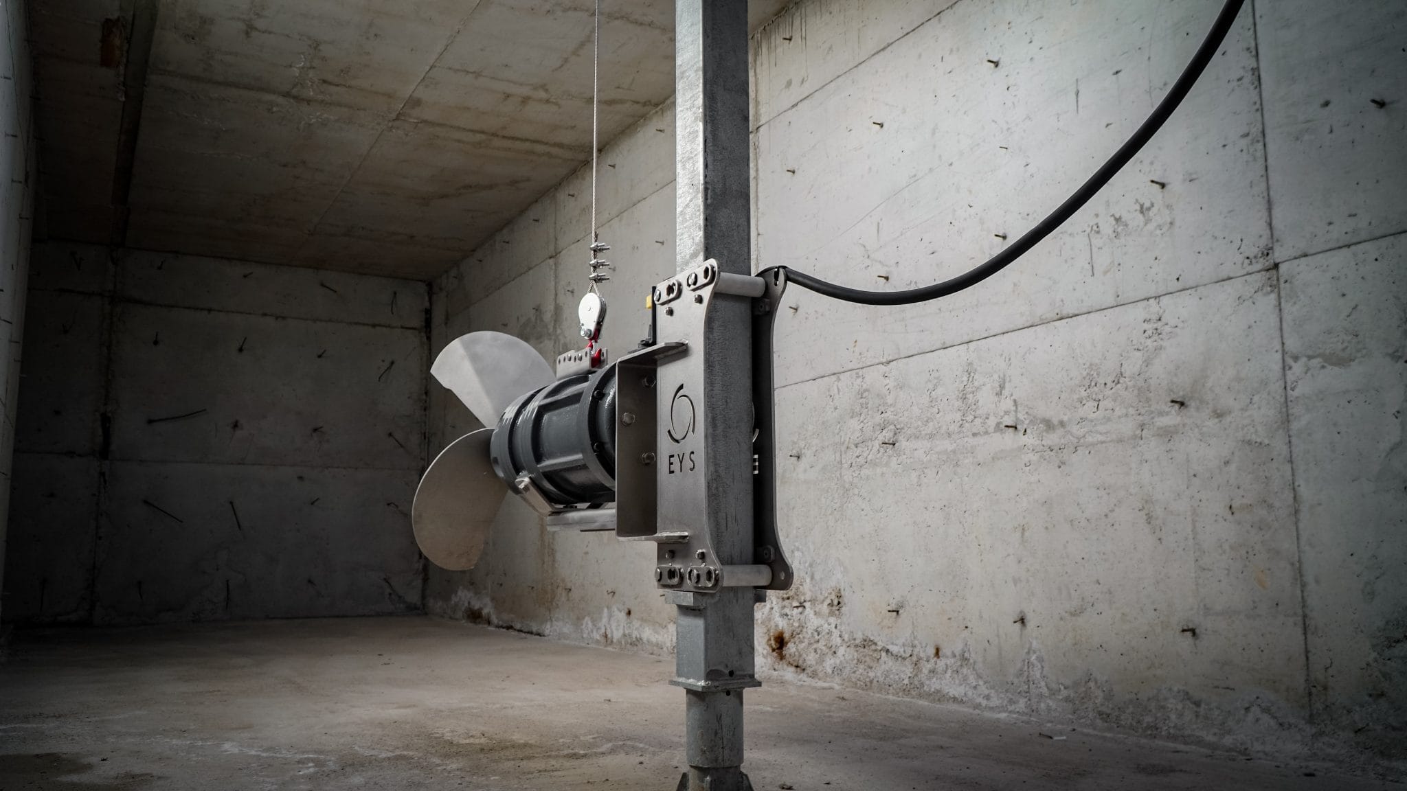 Industrial ventilation fan installed in a concrete room for agricultural use.