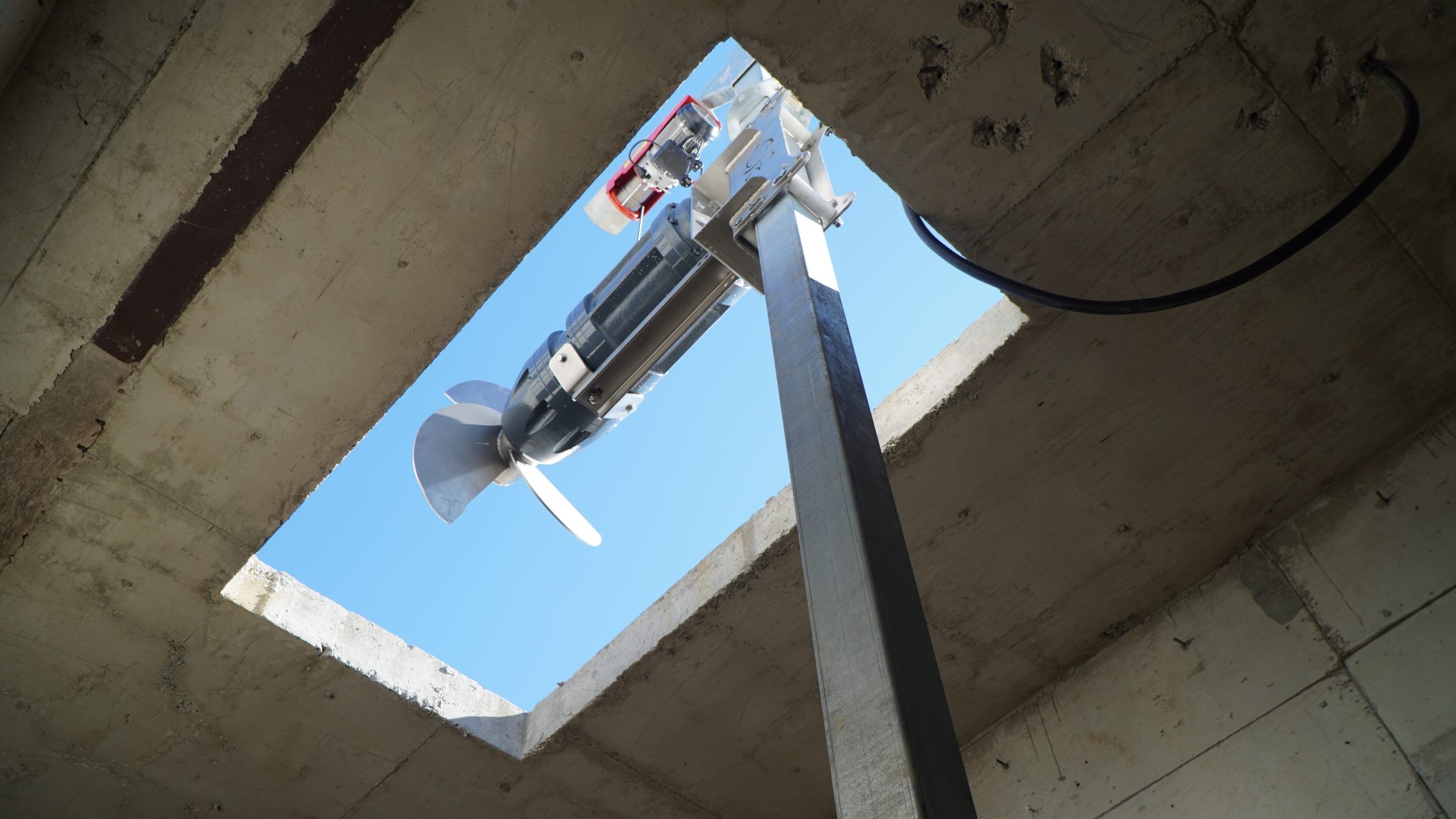 Drone inspecting construction site from below with blue sky background.