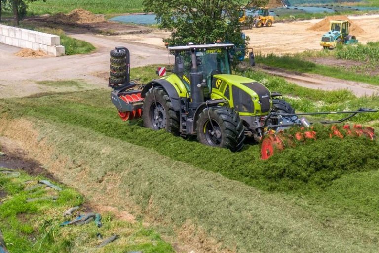 Modern tractor mowing grass on agricultural land in New Zealand.